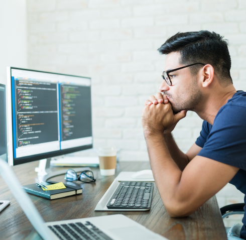thoughtful-young-handsome-programmer-analyzing-software-codes-computer-screens-while-working-from-home
